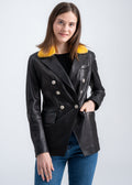 Model wearing a black lambskin leather blazer with a vibrant yellow mink fur collar and double-breasted buttons by Lebeni.