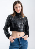 Model wearing a black python leather cropped jacket with ribbed hem, high collar, and metal details by Lebeni.