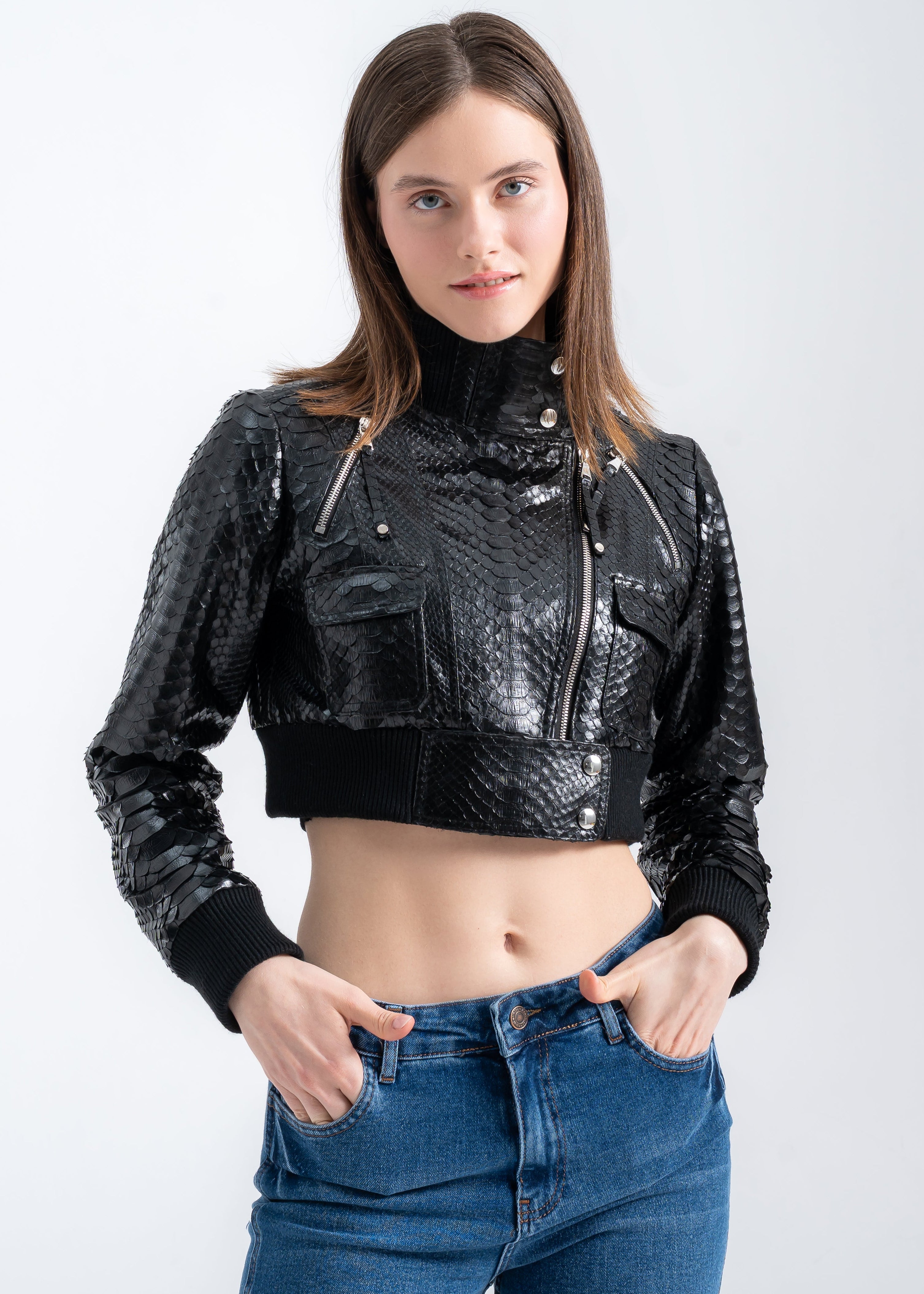 Model wearing a black python leather cropped jacket with ribbed hem, high collar, and metal details by Lebeni.