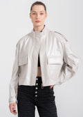 Model wearing a light beige lambskin leather jacket with structured flap pockets and a stand collar, showcasing modern minimalist style by Lebeni.