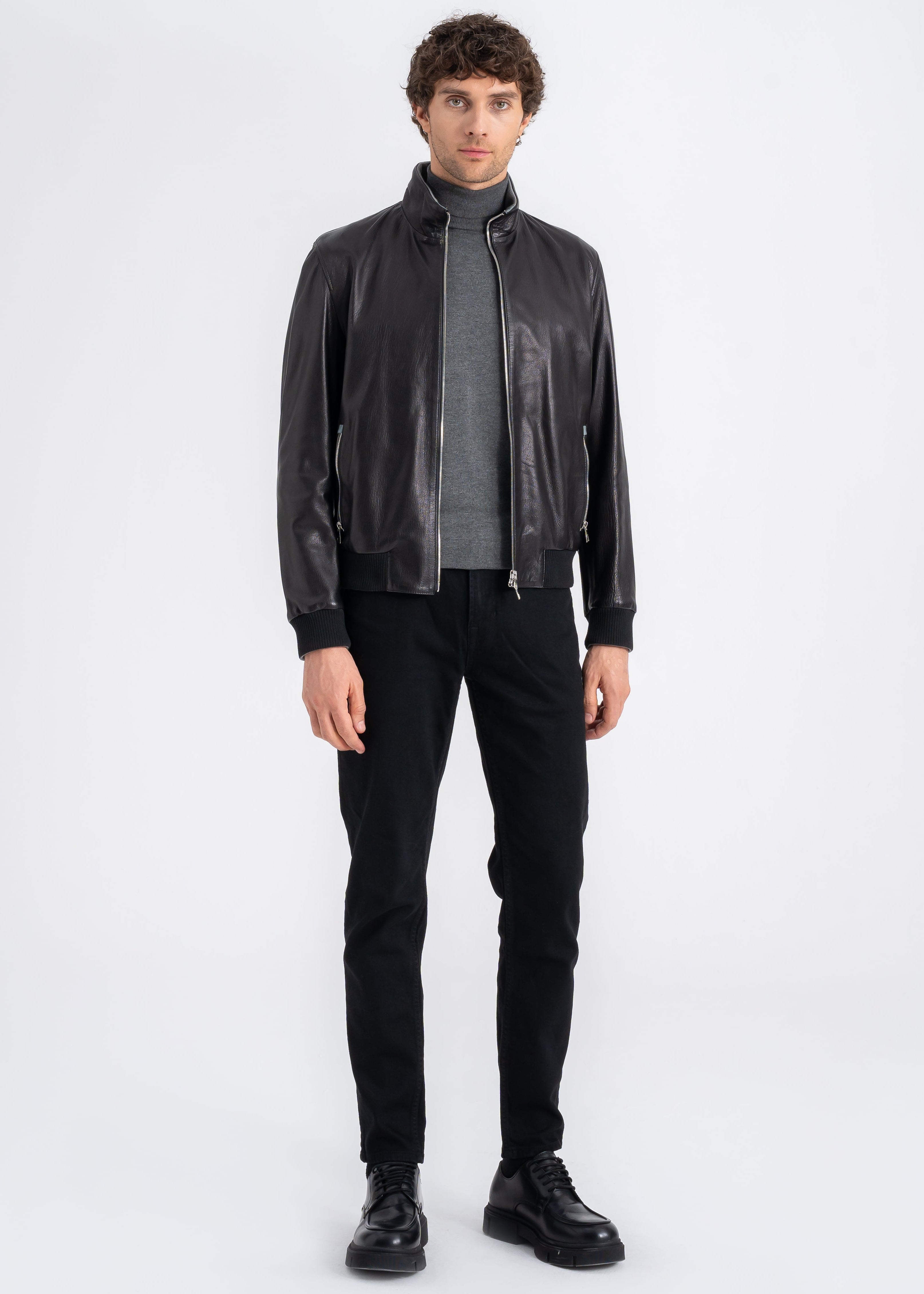 Man wearing a black lamb leather bomber jacket with stand collar, ribbed hem and cuffs, and front zip pockets by Lebeni.