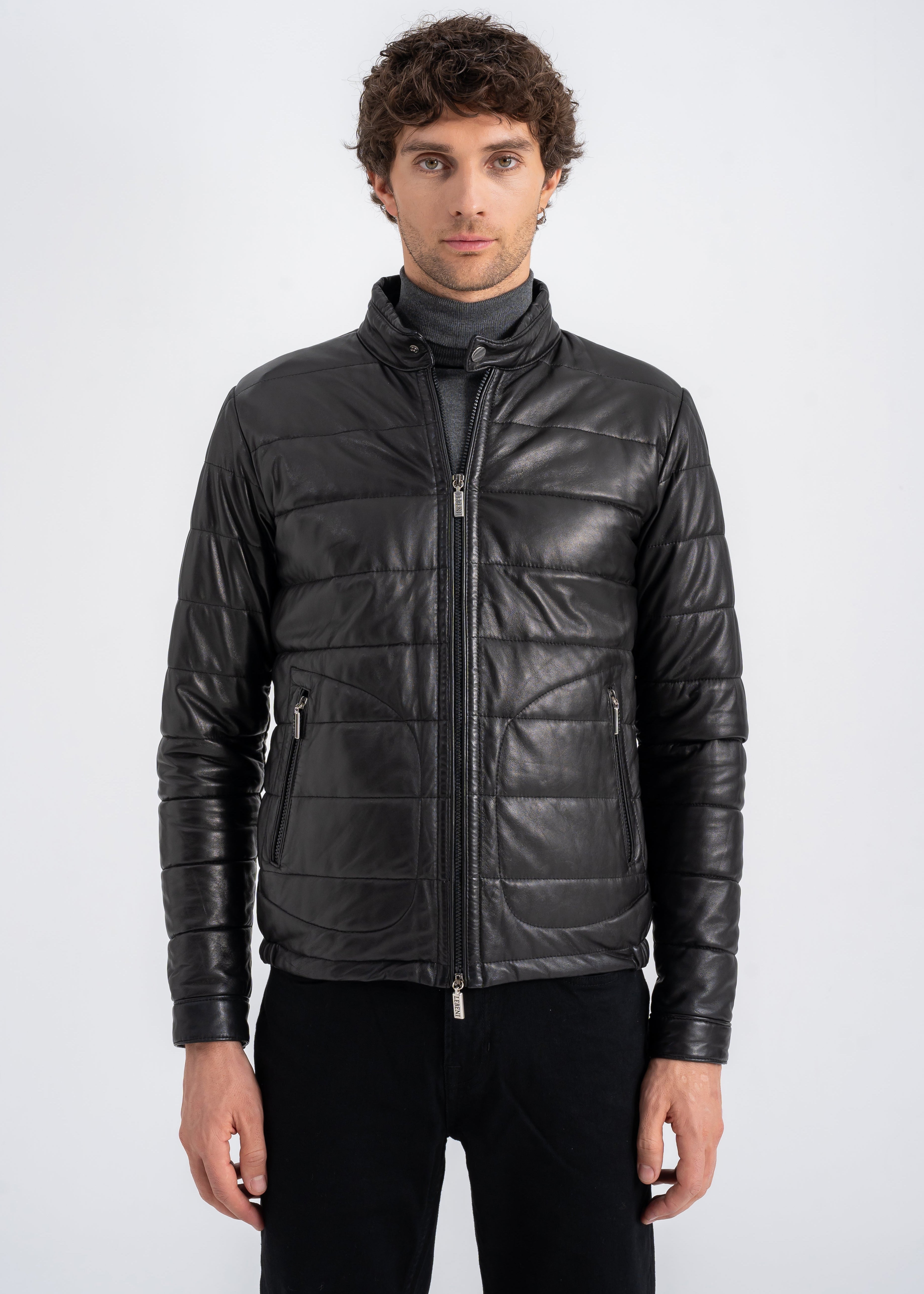 Man wearing a black lamb leather quilted jacket with stand collar, front zipper and side zip pockets by Lebeni.