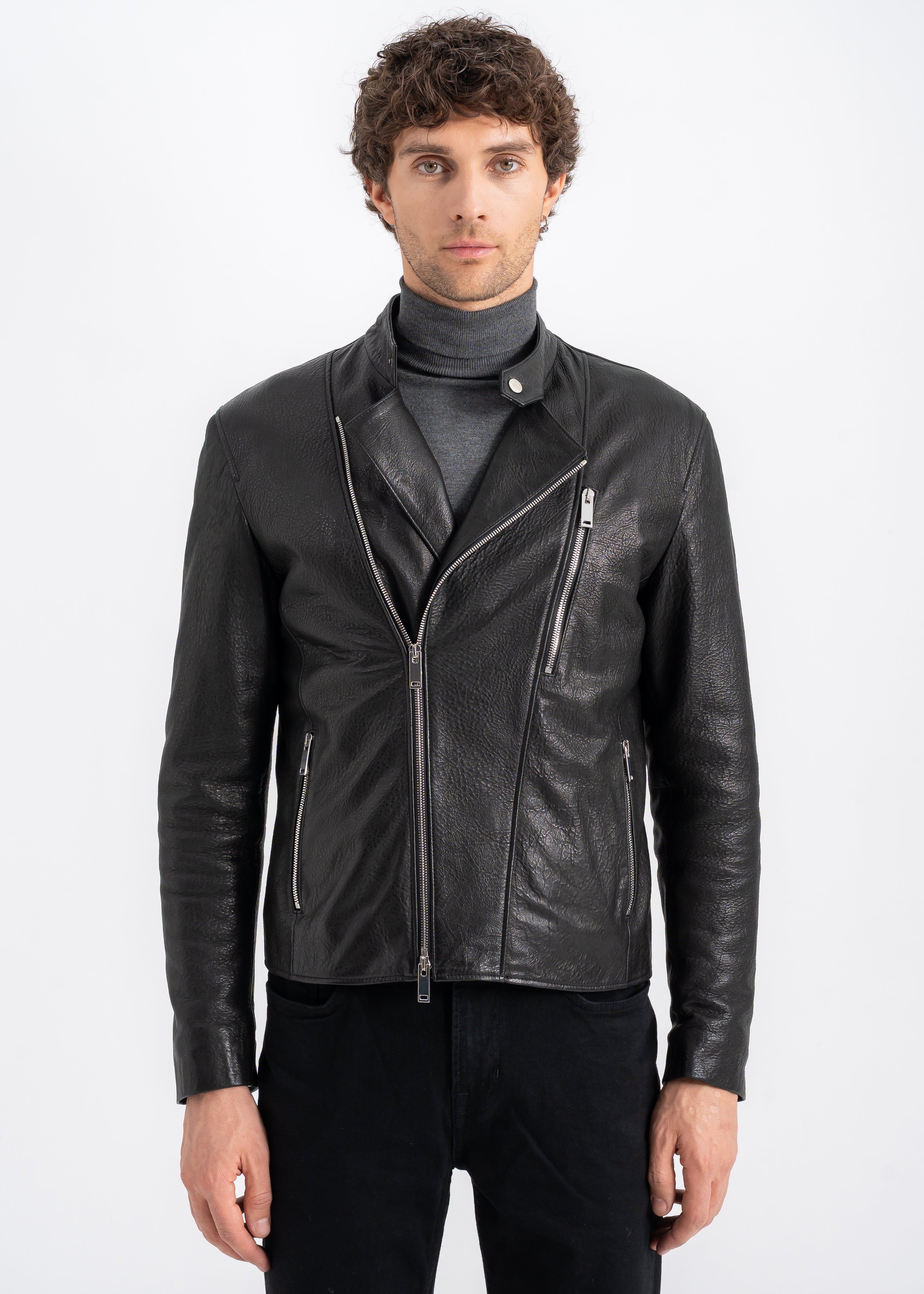 Man wearing a black lambskin biker jacket with asymmetrical zipper, snap-tab collar, and silver hardware by Lebeni.