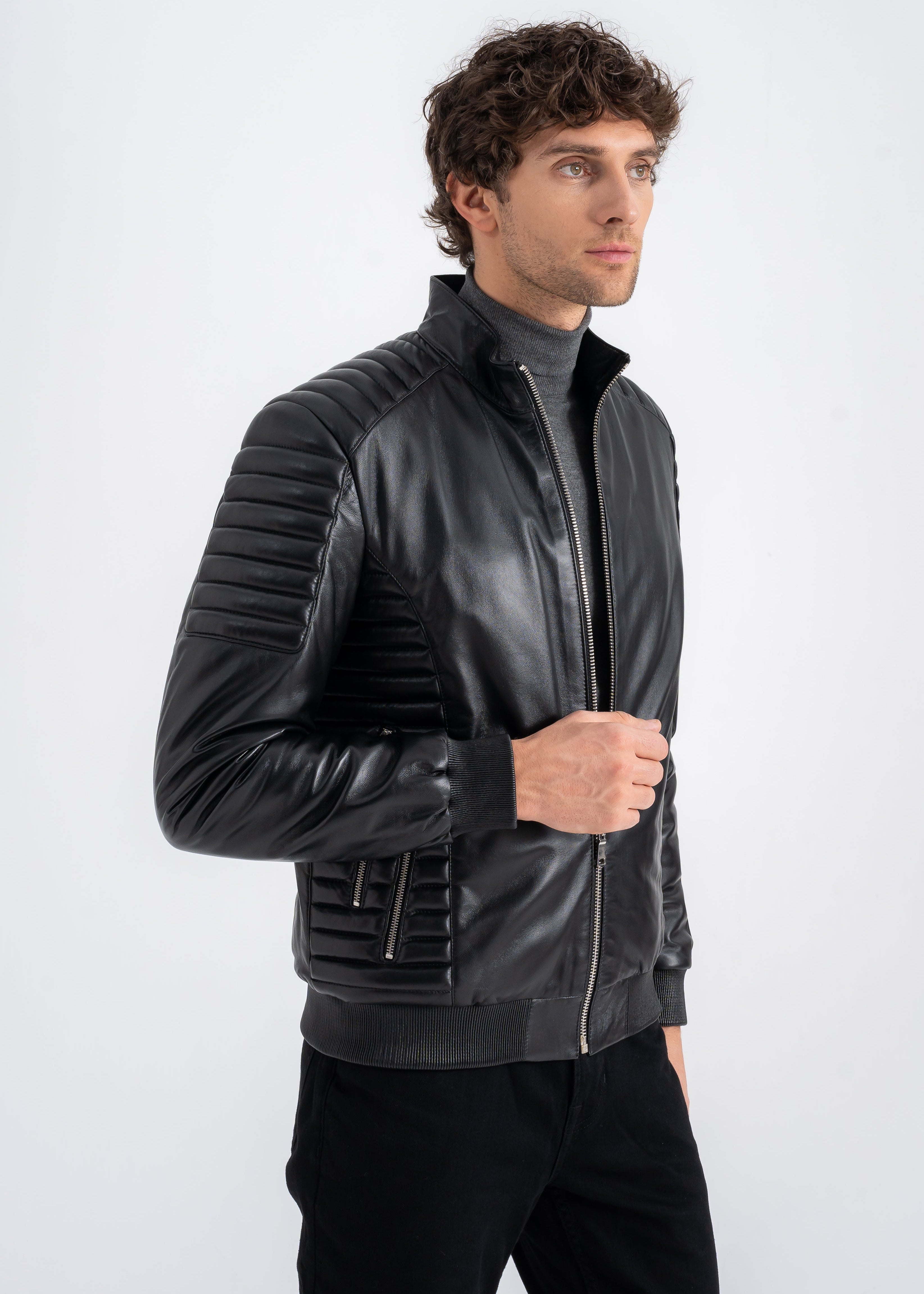 Man wearing a slim black lambskin biker jacket with quilted shoulders, ribbed cuffs and zip pockets by Lebeni.