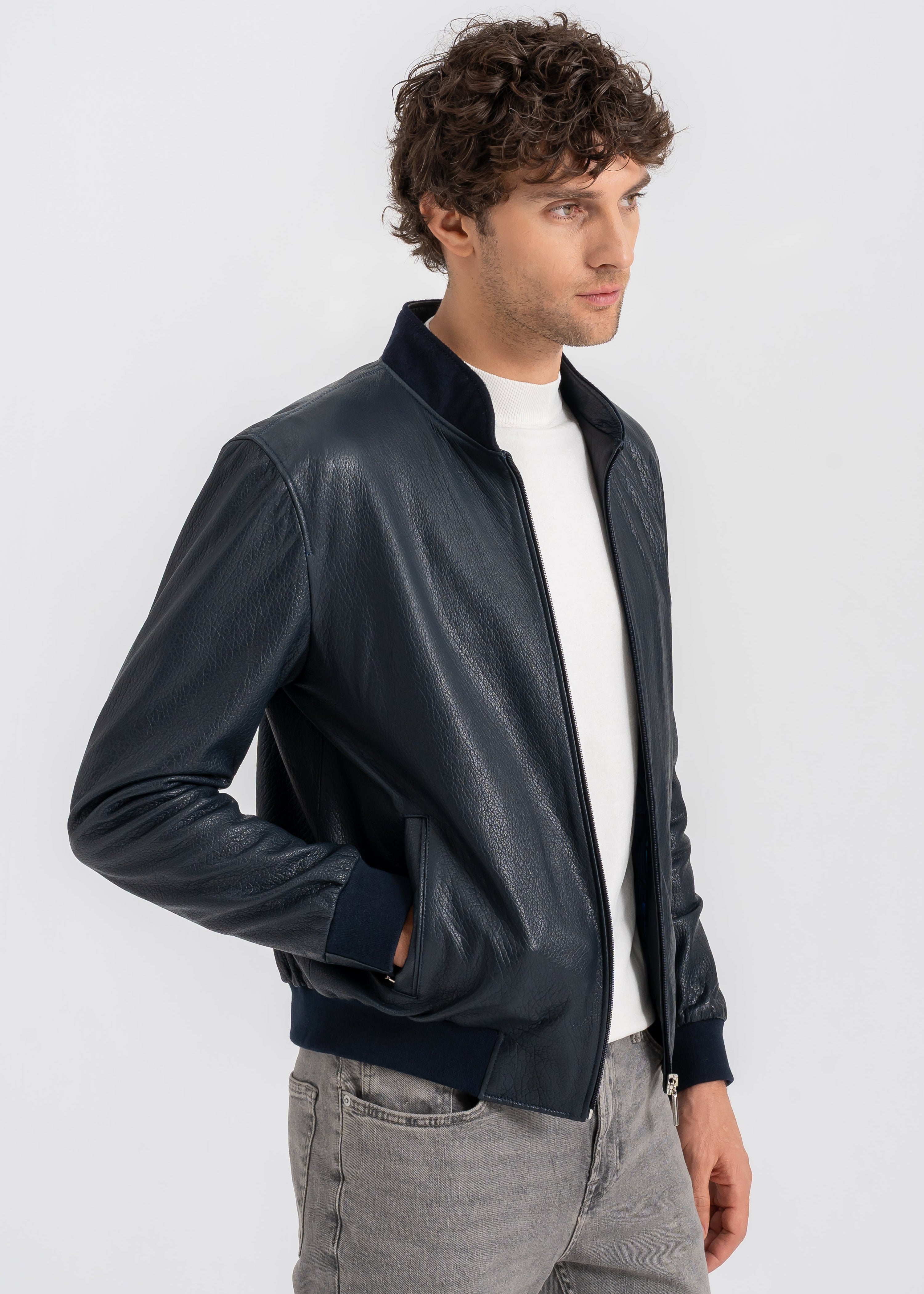 Model wearing a navy blue lambskin leather jacket with zipper closure and minimalist design, showcasing modern elegance by Lebeni.