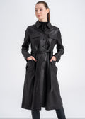 Model wearing a black lambskin utility trench coat with button front, belted waist, and four front pockets by Lebeni.