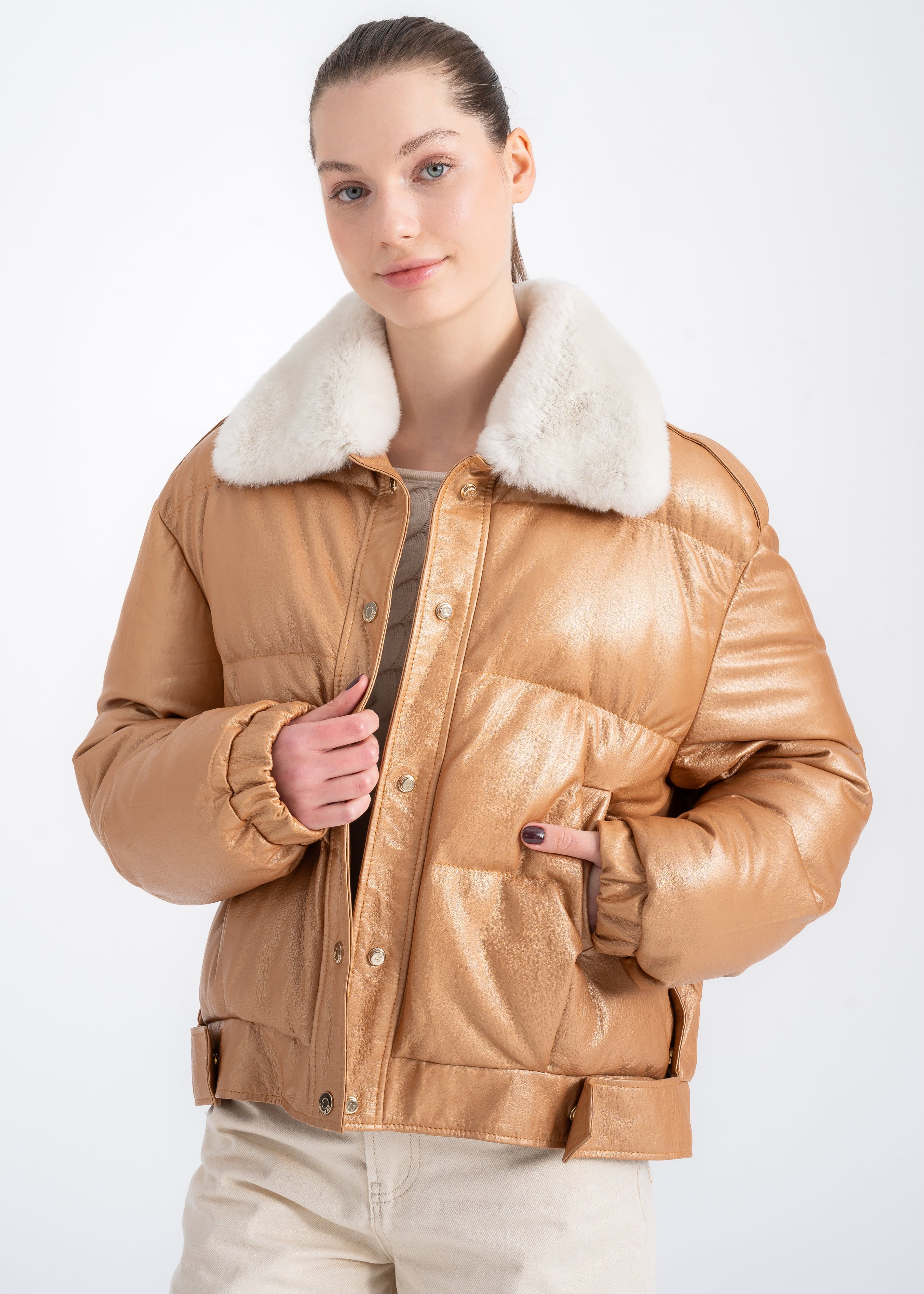 Woman wearing a camel lambskin puffer jacket with soft white real fur collar and boxy cropped silhouette by Lebeni.