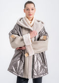 Woman wearing a hooded shearling jacket with metallic quilted nylon body, beige leather sleeves, shearling cuffs and strap buckle sleeve detail by Lebeni.