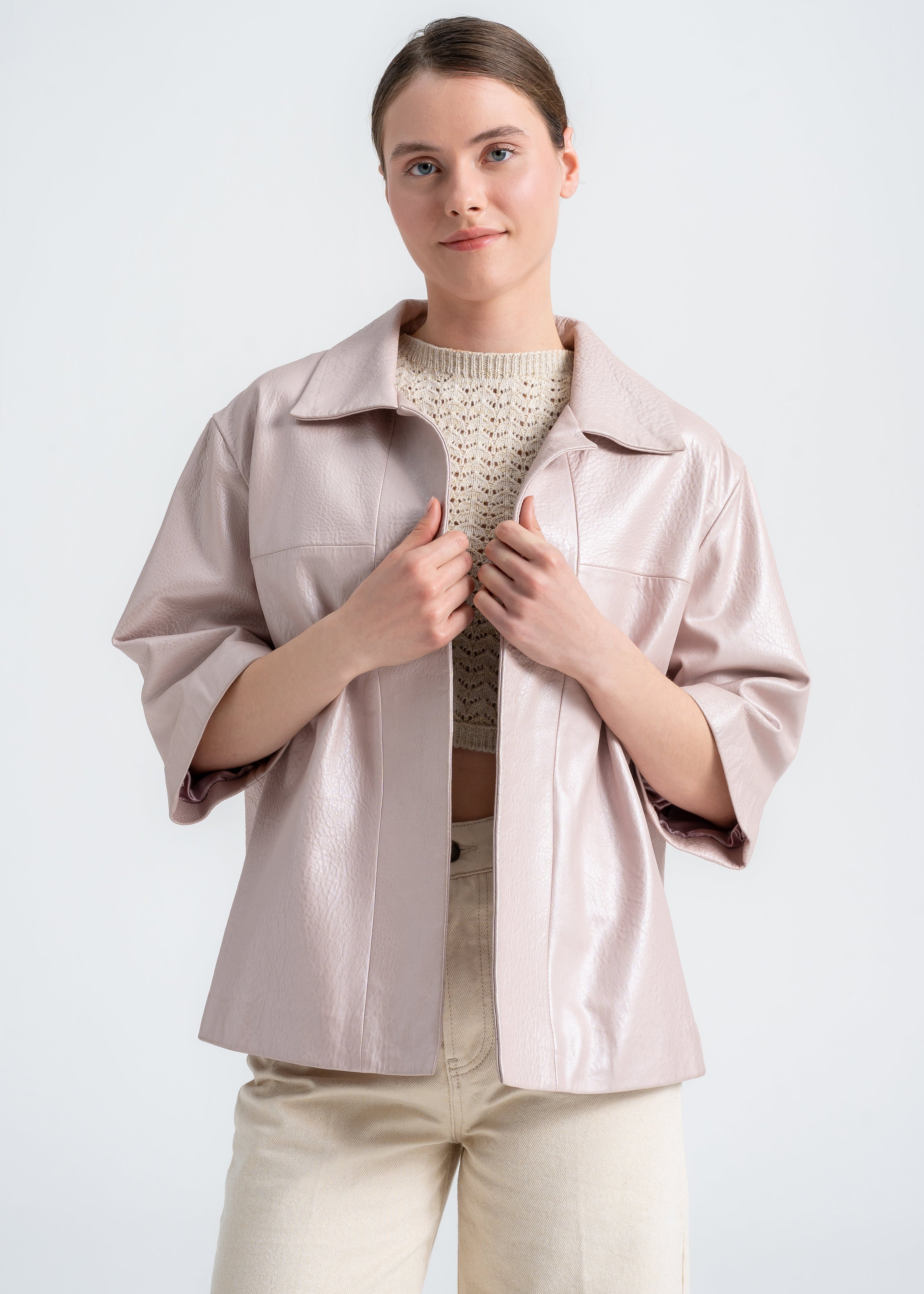 Model wearing a blush lambskin boxy jacket with open front, wide sleeves, and clean minimal design by Lebeni.