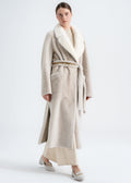 Model wearing a light beige reversible shearling coat by Lebeni with mink fur shawl collar, tie belt and python detailed trims at the belt and side slits.